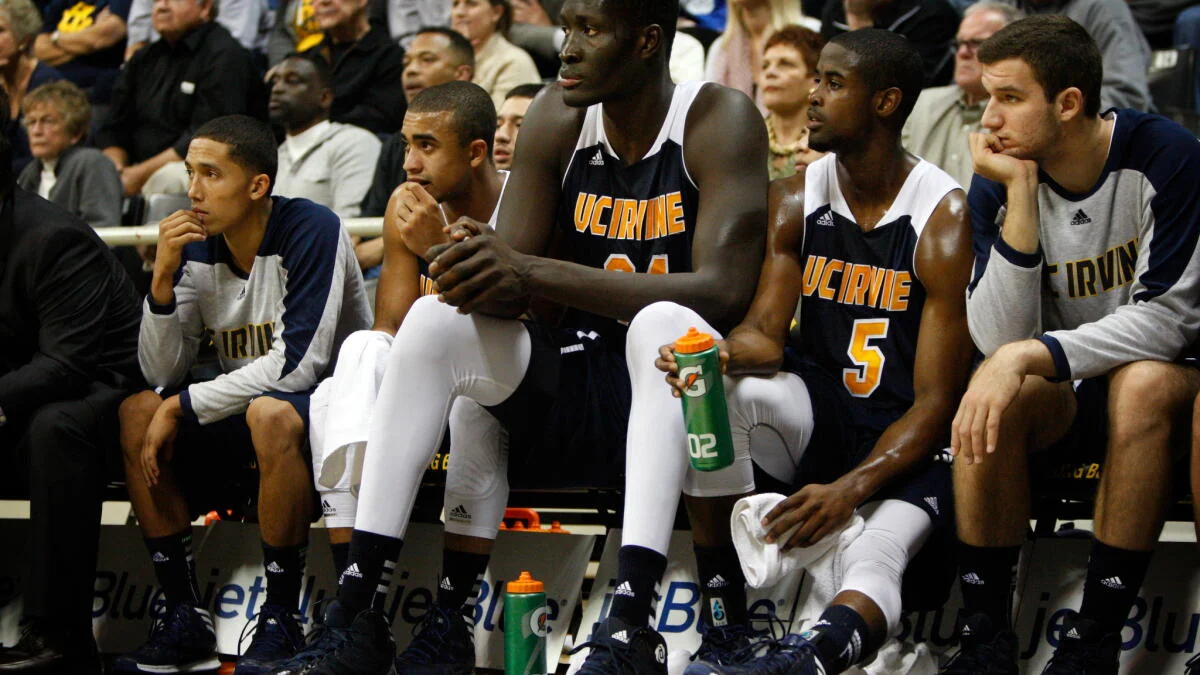 UC Irvine basketball players sit on the bench watching a game