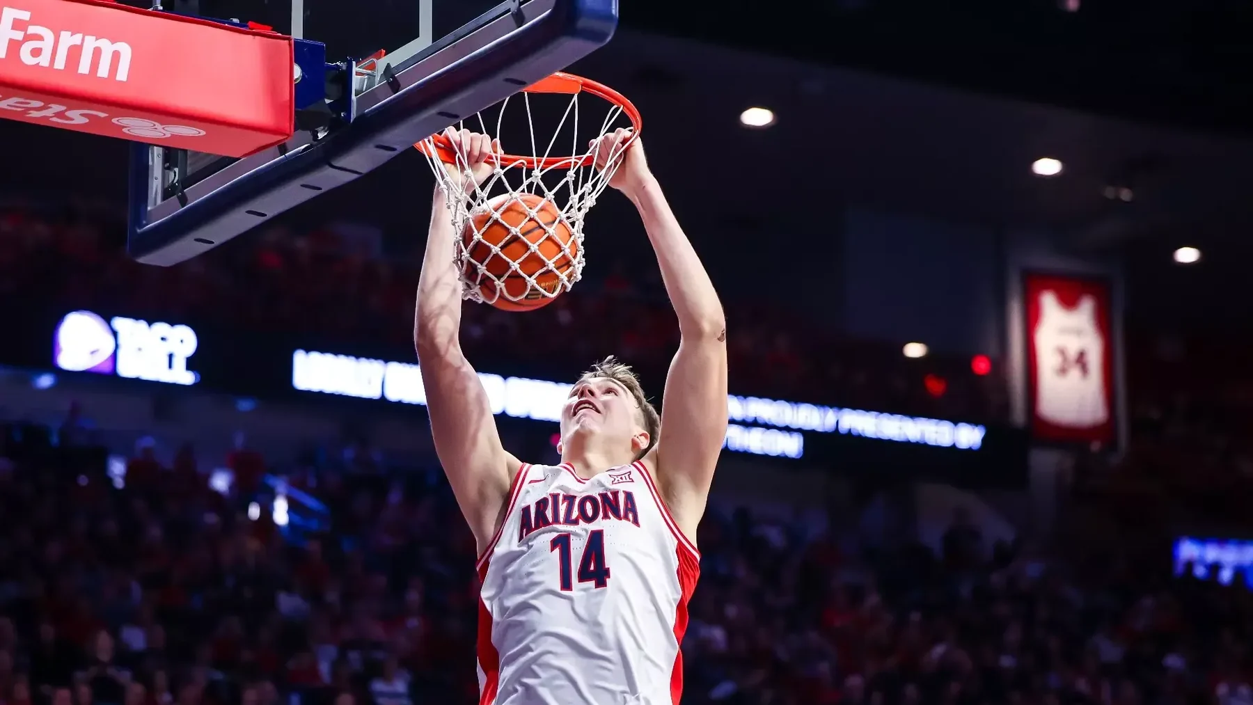 Motiejus Krivas dunks in a white Arizona number 14 uniform at McKale Center