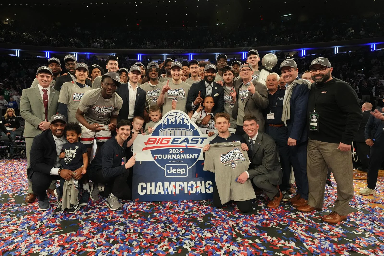 UConn players and staff pose with the 2024 BIG EAST tournament champions sign