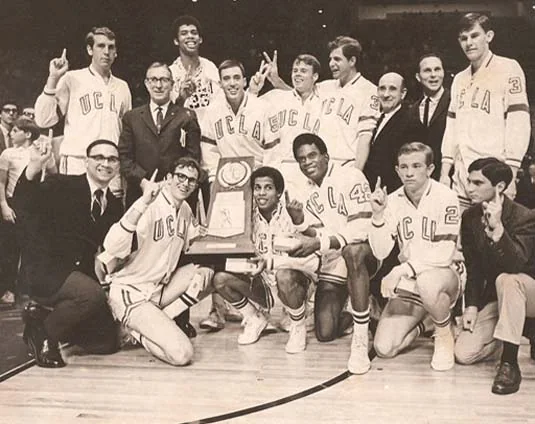 John Wooden posing with a UCLA men's basketball championship team