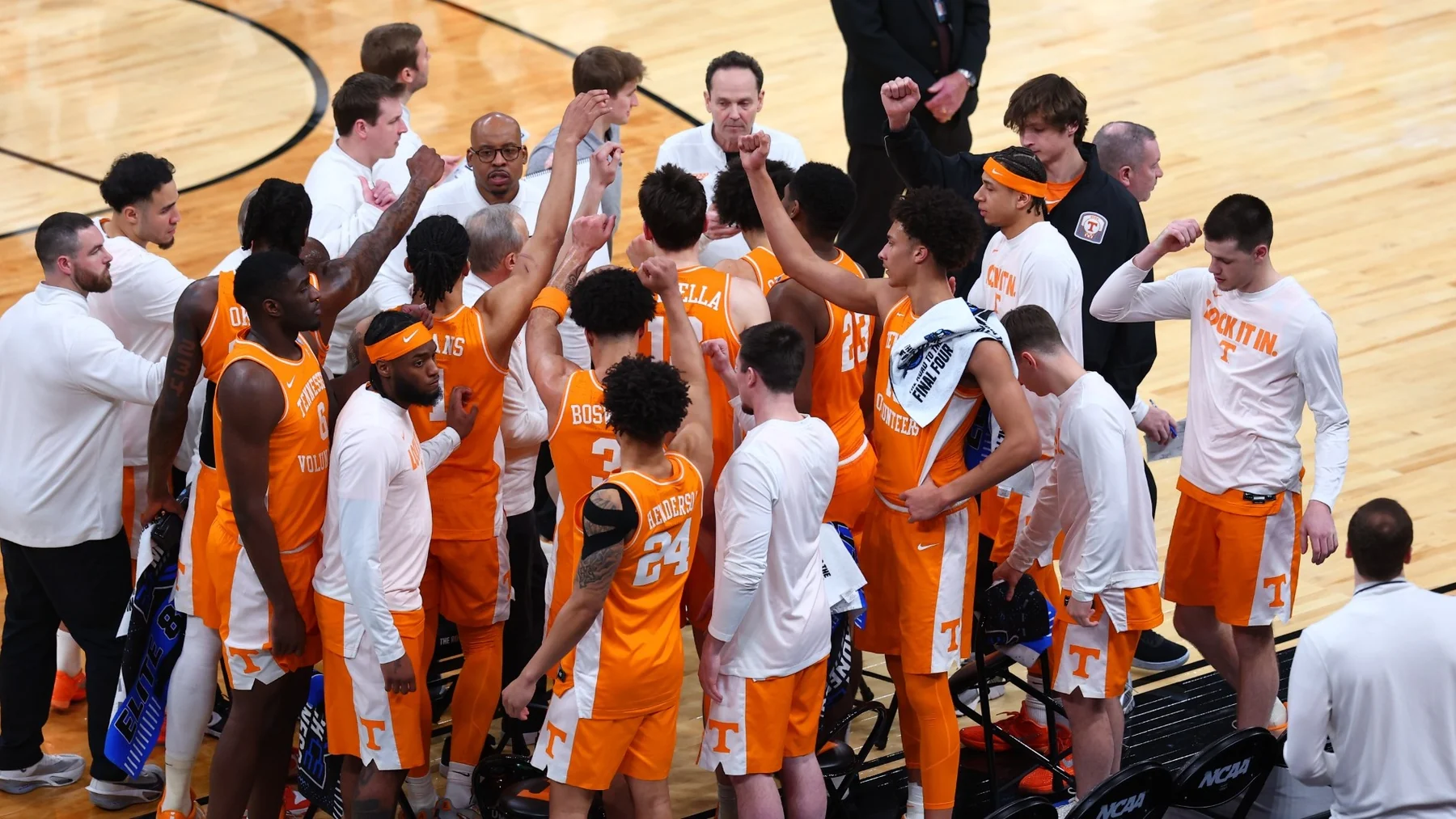 Tennessee players and coaches gather in a courtside huddle