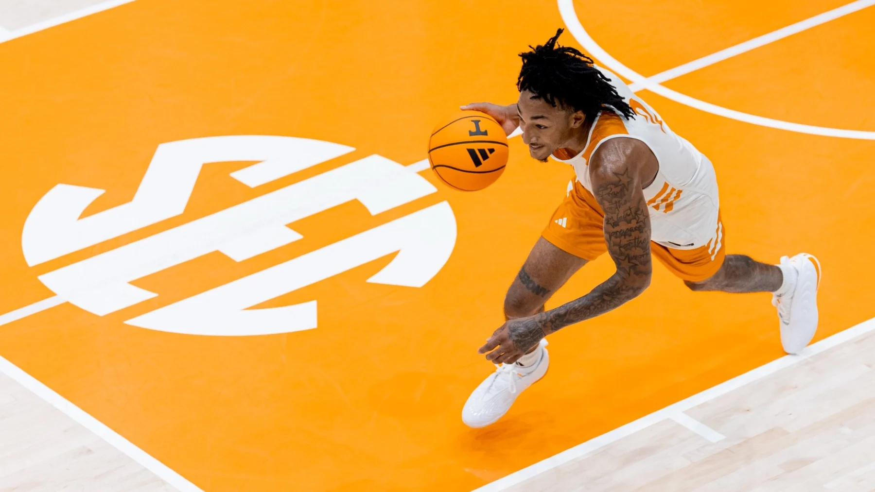Tennessee player dribbles across the orange practice court