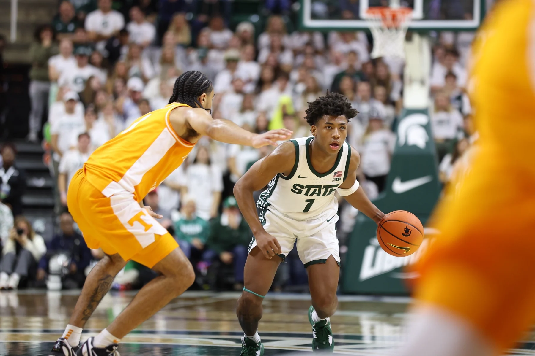 Michigan State guard Jeremy Fears Jr. dribbles beside a Tennessee defender in orange