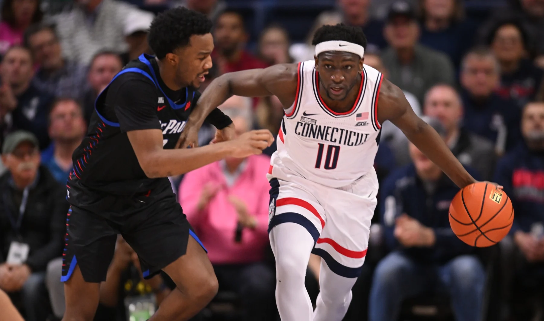 Connecticut number 10 dribbling alongside a DePaul defender
