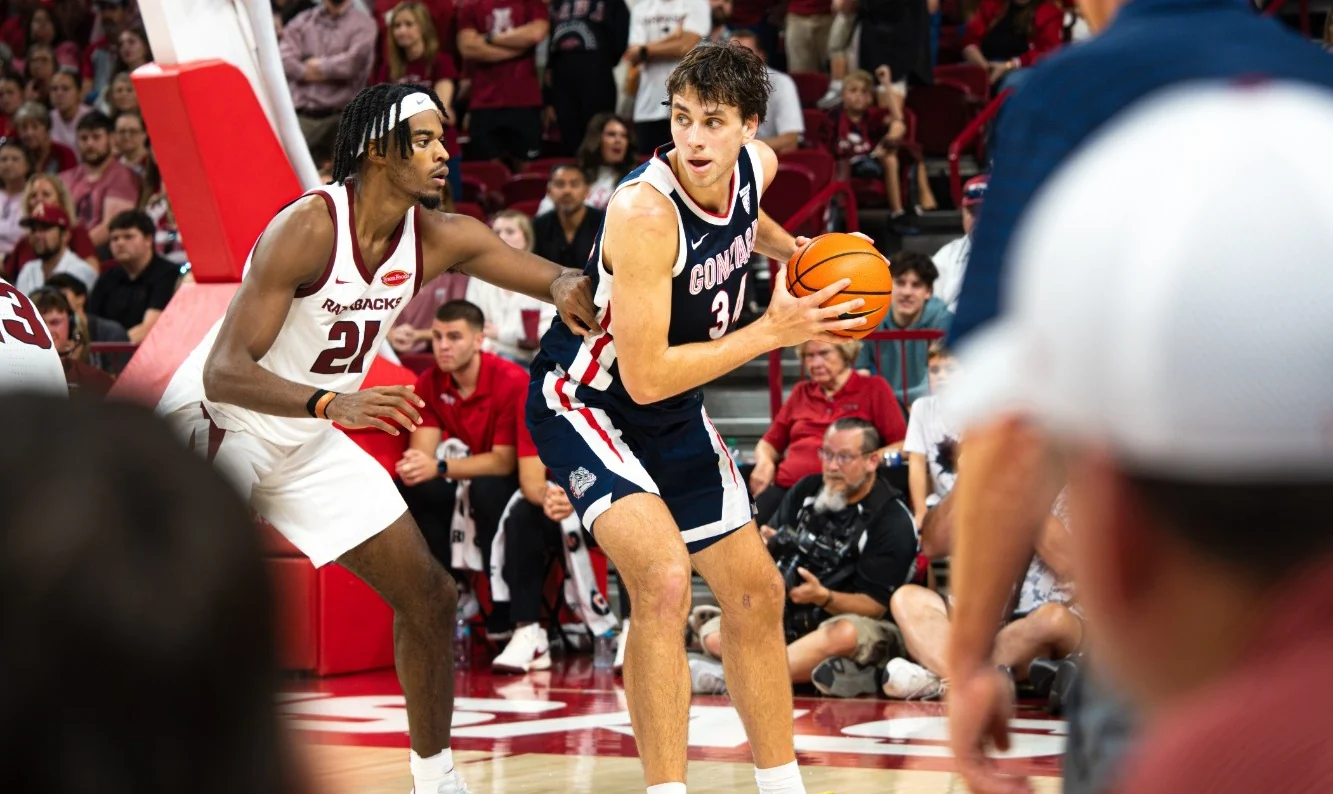 A Gonzaga ballhandler holds the ball while a Razorbacks defender guards him