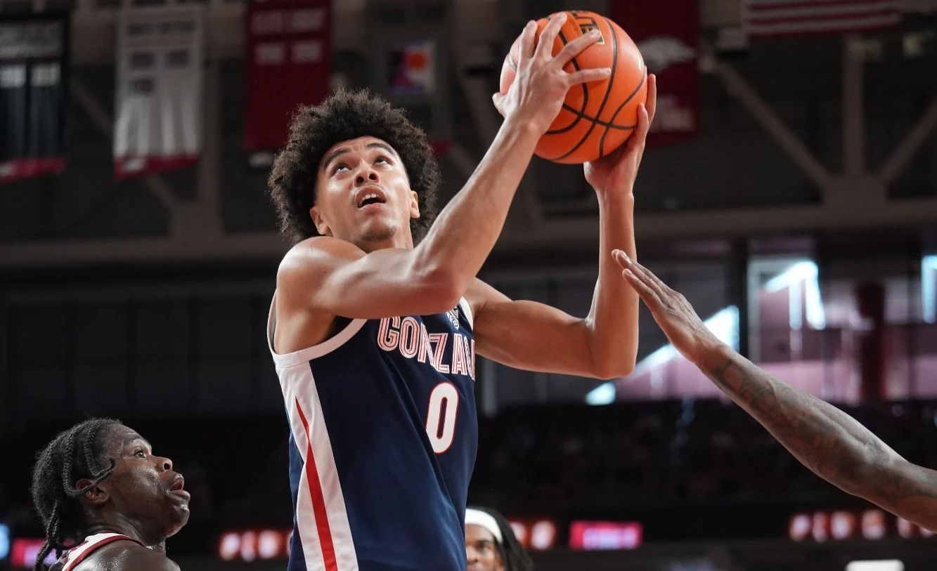 A Gonzaga player raises the ball for a shot with defenders reaching nearby