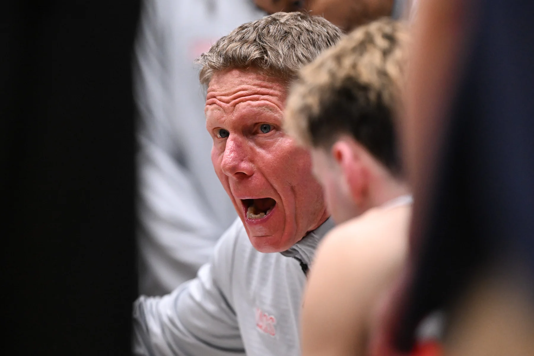 Gonzaga coach Mark Few speaks with players gathered closely around him