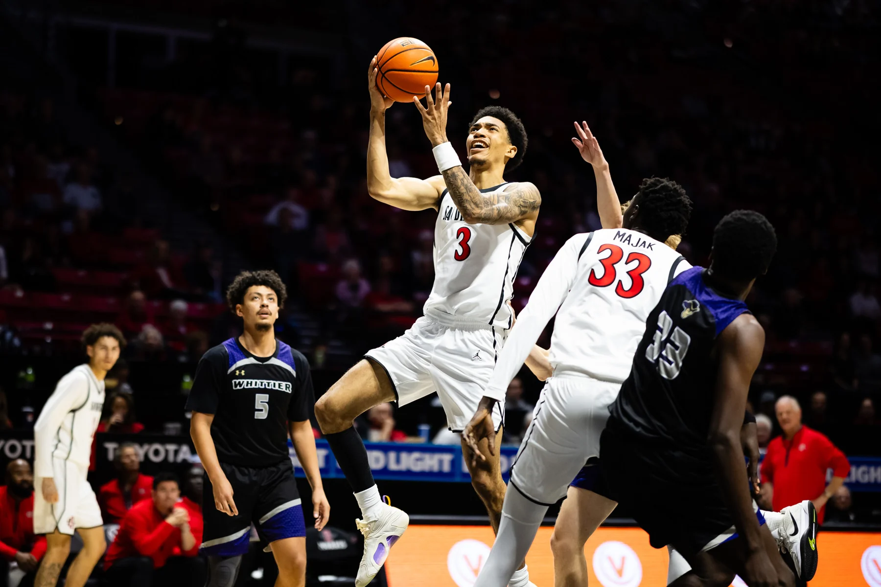 San Diego State player takes a layup with Whittier defenders nearby
