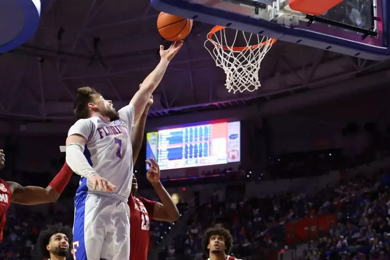 Florida player attempts a layup against Alabama defenders in an earlier game