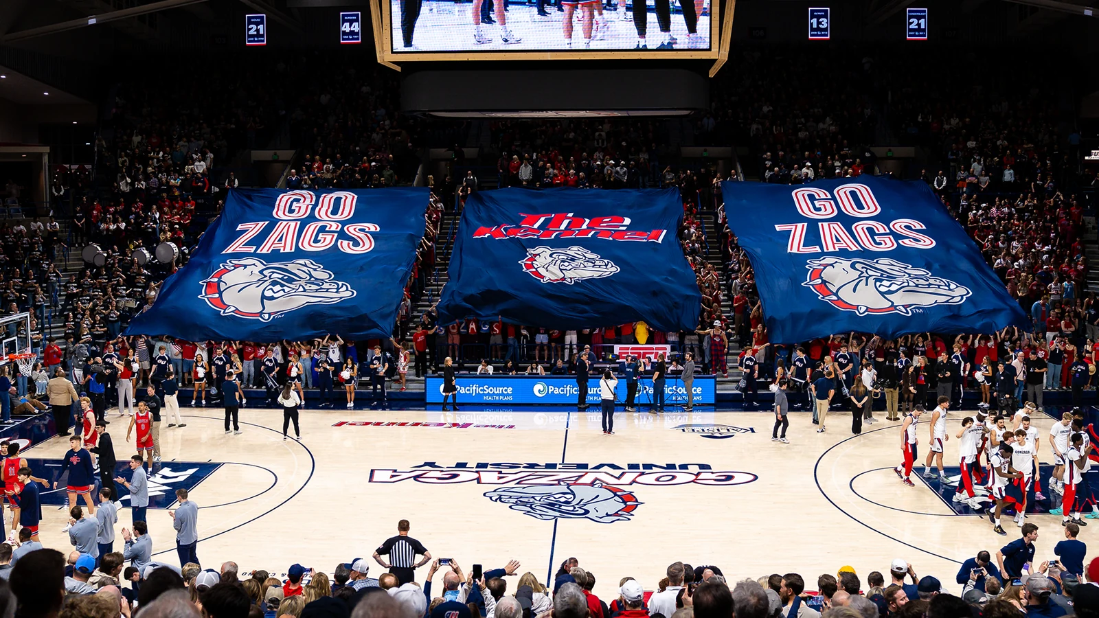 Gonzaga supporters holding large blue banners over the McCarthey Athletic Center court