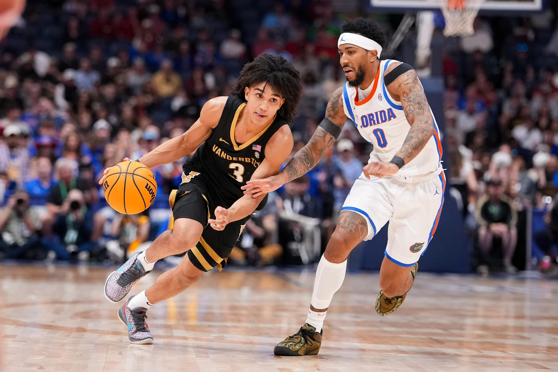 Tyler Tanner dribbles in a black Vanderbilt uniform against a Florida defender