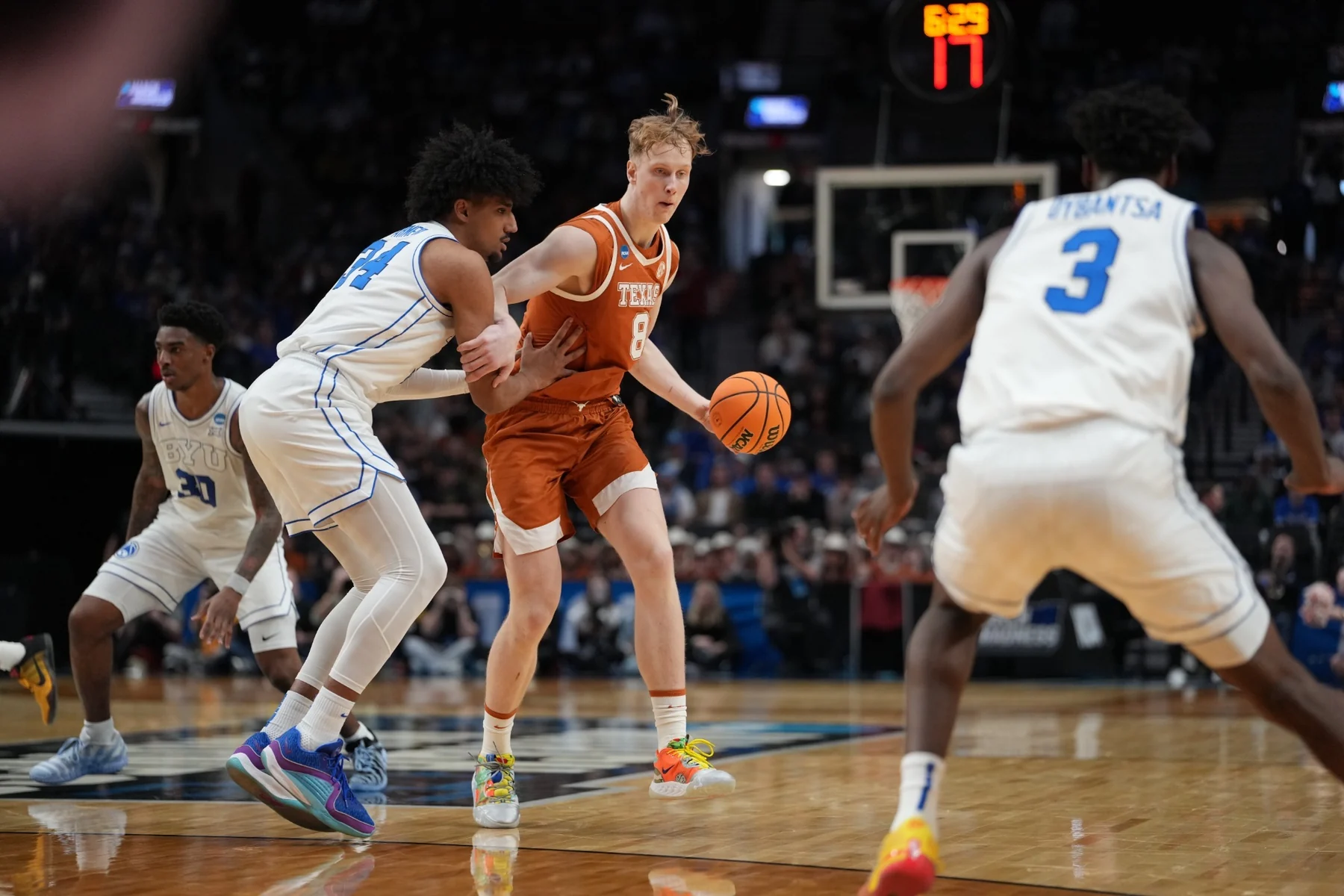 Texas number 8 dribbling while BYU defenders close around him