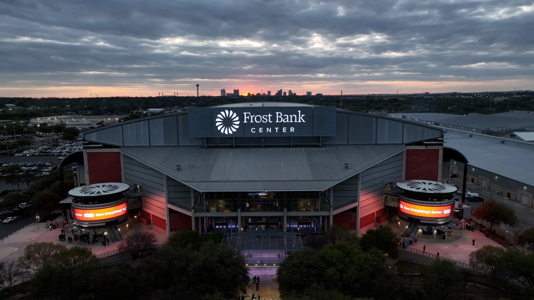 Frost Bank Center exterior at dusk with its illuminated building sign
