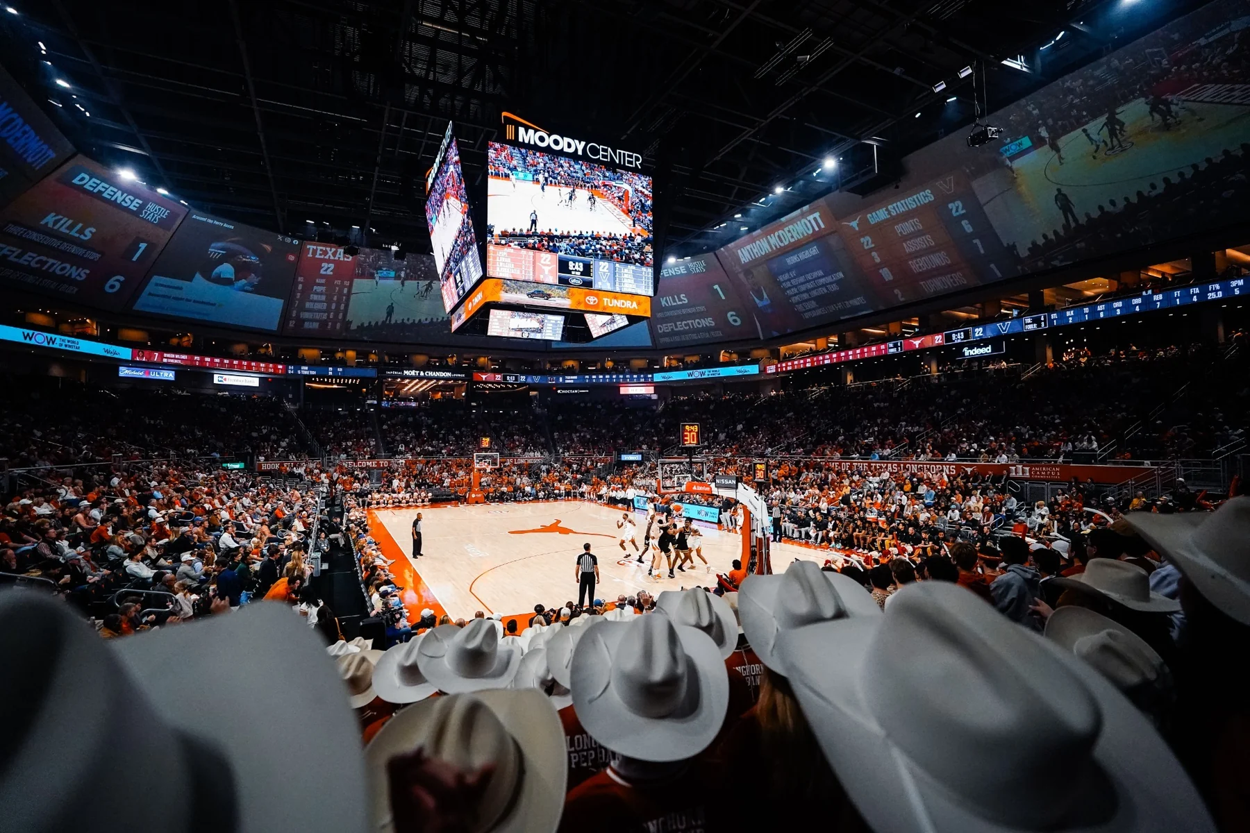 Moody Center basketball floor and crowd viewed from behind the band