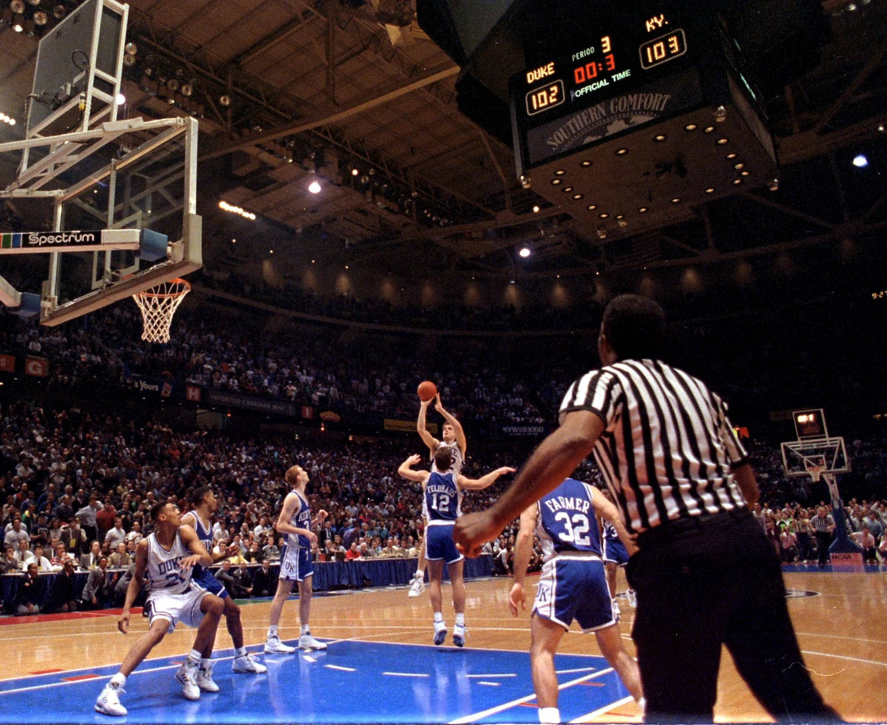 A Duke player in white takes a contested shot against Kentucky defenders in blue